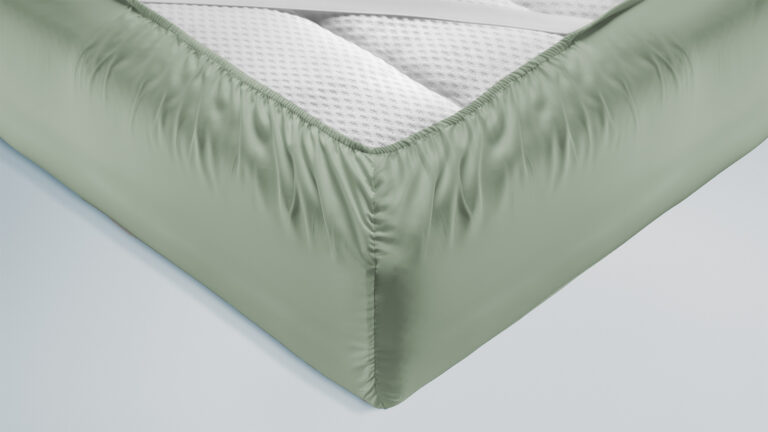 Zoom in on the corner and the diagonal elastic band of a green fitted sheet