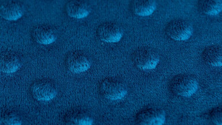 Close-up op het textiel van een blauw minky gestippeld overtrek