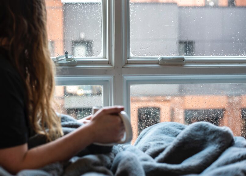 Girl lying in bed under blanket
